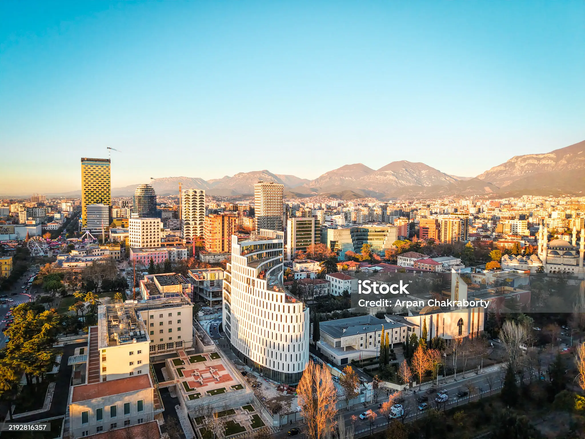 Panoramic view of Tirana’s city center and surrounding mountains at sunset
